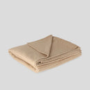 Béžová deka z polyesteru s prímesou metalizovaného vlákna.