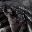 Sivá polyesterová deka.