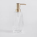 Transparentný sklenený dávkovač so zlatou pumpičkou. 