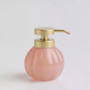 Ružový dávkovač so zlatou pumpičkou.