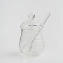 Transparentná sklenená nádoba na med.
