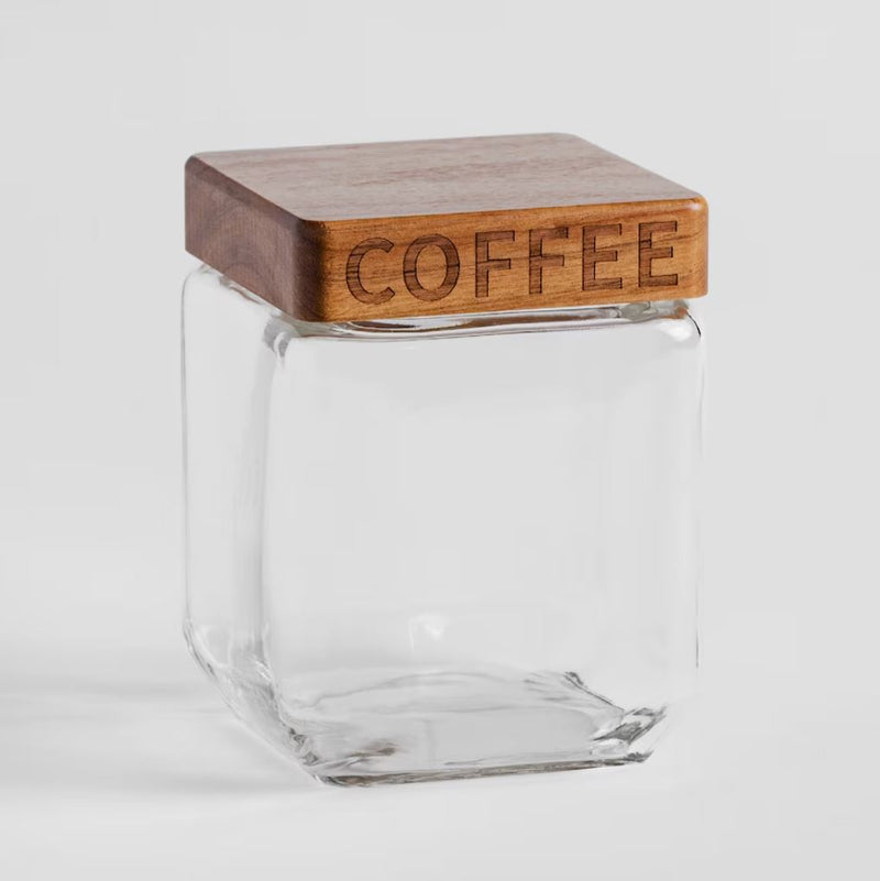 Transparentná dóza s hnedým dreveným uzáverom a nápisom COFFEE.
