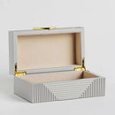 Sivá šperkovnica so zlatými doplnkami. 