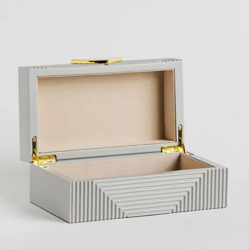 Sivá šperkovnica so zlatými doplnkami. 