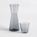 Sivá sklenená karafa s pohárom. 