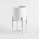 Biely kovový kvetináč.