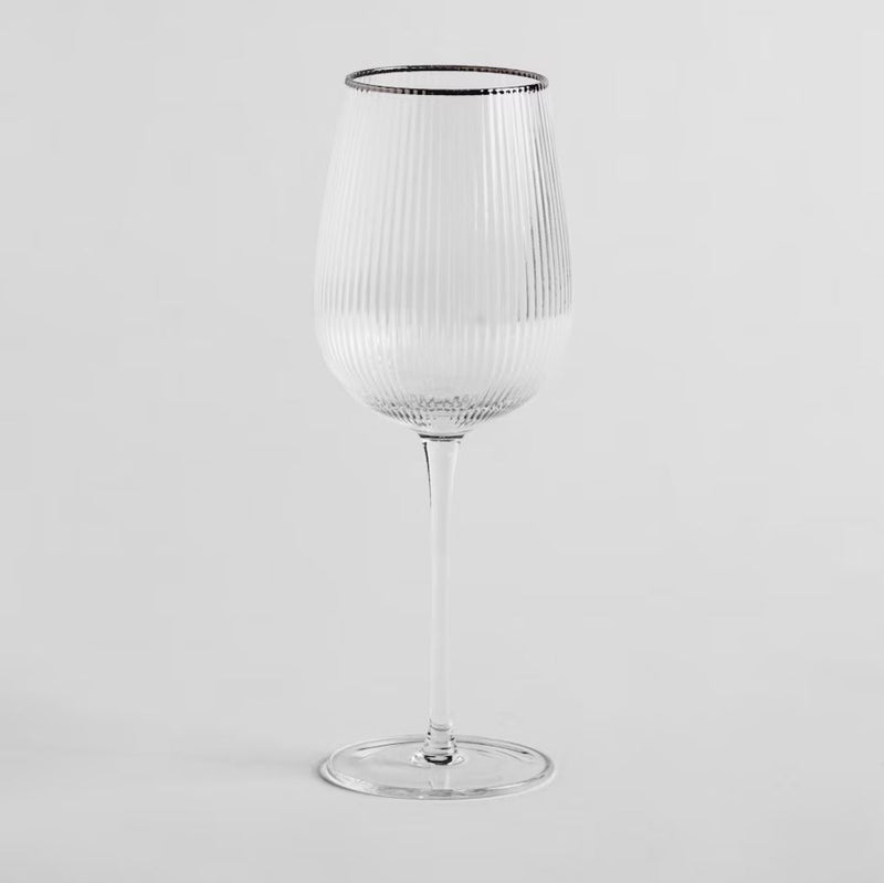 Transparentný pohár na víno so strieborným lemom.