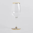 Transparentný pohár na víno zo zlatým lemom.