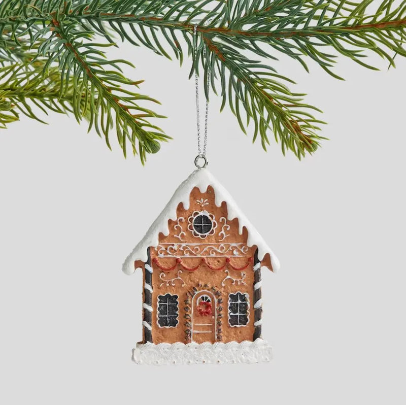 Hnedá vianočná ozdoba v podobe perníkového domčeka.