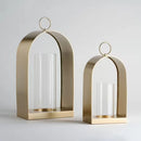 Zlatý kovový lampáš so skleneným miestom na sviečku. 