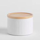 Biela kovová dóza s dreveným uzáverom.