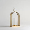 Zlatý kovový lampáš so skleneným miestom na sviečku. 