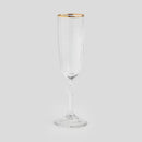 Transparentný pohár na šampanské so zlatým lemom.