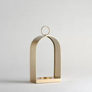 Zlatý kovový lampáš so skleneným miestom na sviečku. 