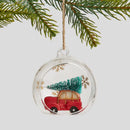 Červená vianočná ozdoba v podobe autíčka s vianočným stromčekom.