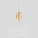 Transparentný pohár na šampanské so zlatou dekoráciou.