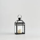 Čierny železný lampáš so sklenenými stenami.