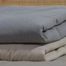 Sivý prehoz na posteľ. 