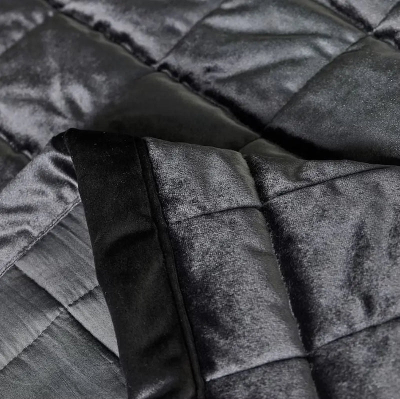 Sivý prehoz na posteľ.