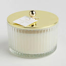 Transparentná vonná sviečka so zlatým krytom.