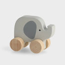 Sivá drevená detská hračka v podobe sloníka s kolieskami.