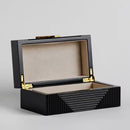 Čierna šperkovnica so zlatými doplnkami.