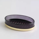 Čierna sklenená mydelnička so zlatou podstavou.