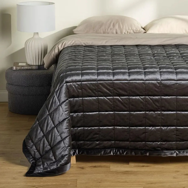 Sivý prehoz na posteľ.