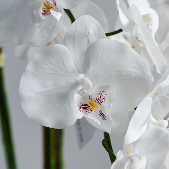 Biely umelý kvet v keramickom kvetináči.