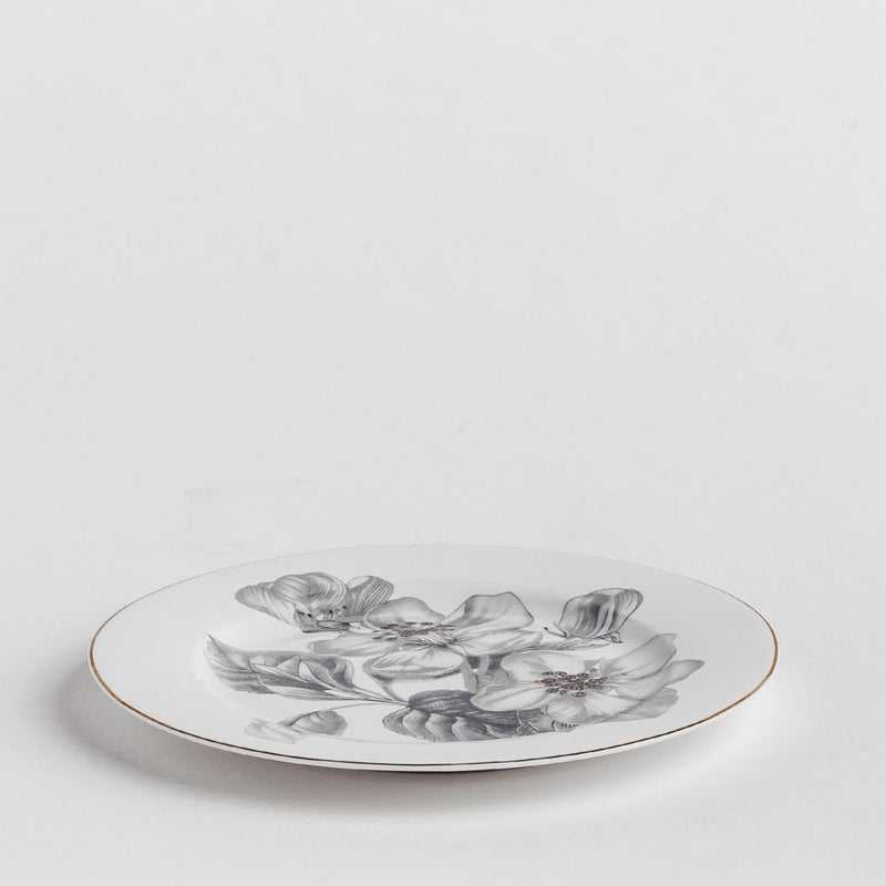 Biely porcelánový dezertný tanier so sivými kvetmi.