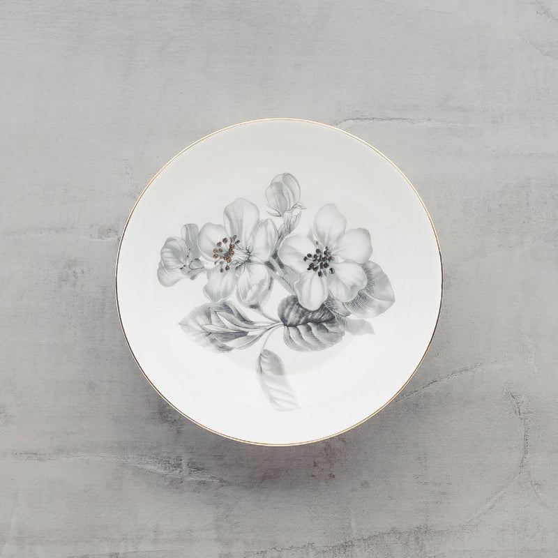 Biely porcelánový dezertný tanier so sivými kvetmi.