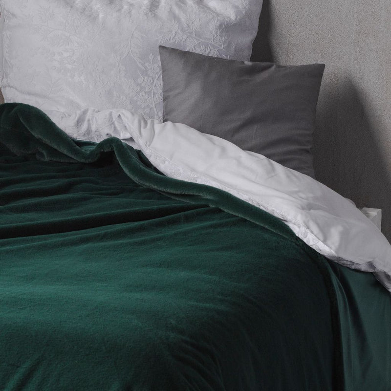 Zelený polyesterový prehoz na posteľ.