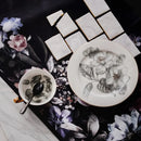 Biely porcelánový plytký tanier so sivými kvetmi. 