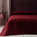 Červený polyesterový prehoz na posteľ.