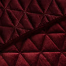 Červený polyesterový prehoz na posteľ.