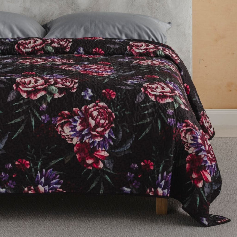 Čierny polyesterový prehoz na posteľ s kvetovým motívom.