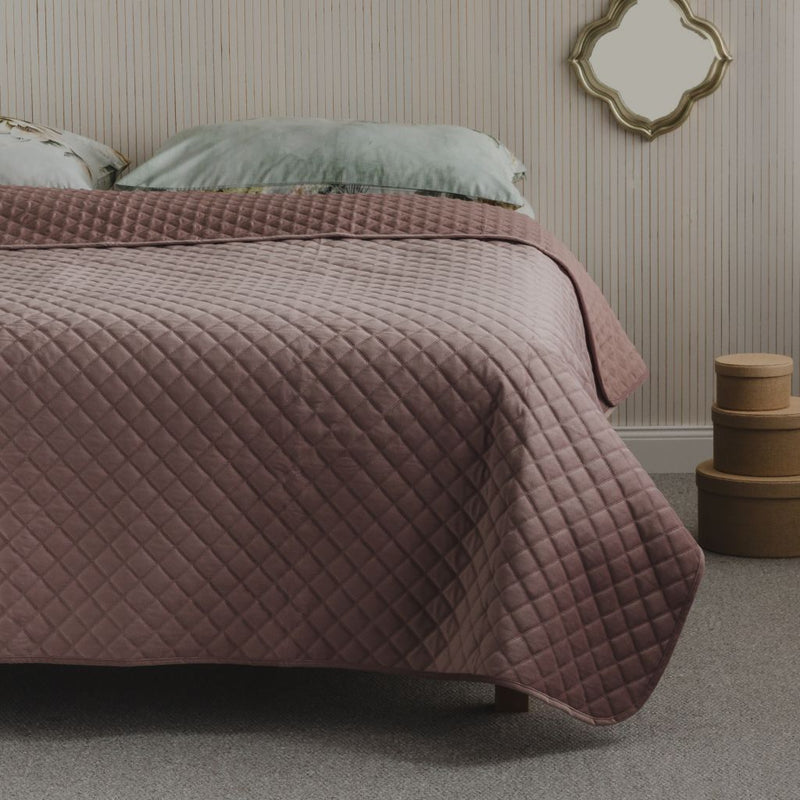 Ružový polyesterový prehoz na posteľ. 