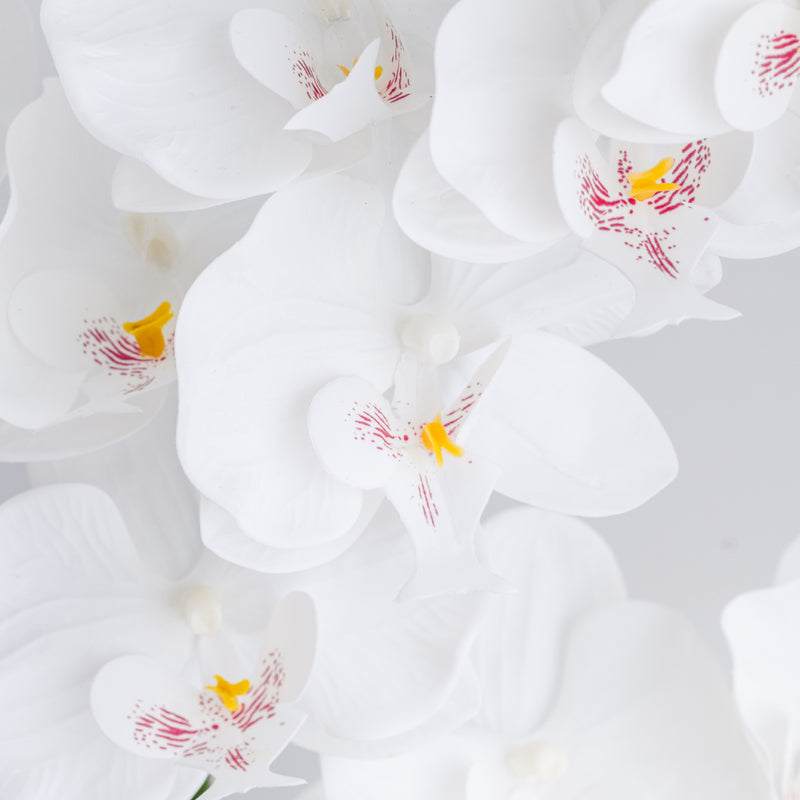 Biely umelý kvet v keramickom kvetináči.