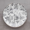 Sivý porcelánový plytký tanier s motívom sivého kvetu a zlatým okrajom. 