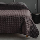 Hnedý polyesterový prehoz na posteľ. 