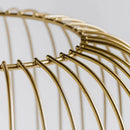 Zlatá lampa na čiernych nožičkách.