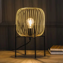 Zlatá lampa na čiernych nožičkách.