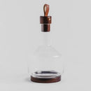 Transparentná sklenená karafa s drevenými doplnkami. 